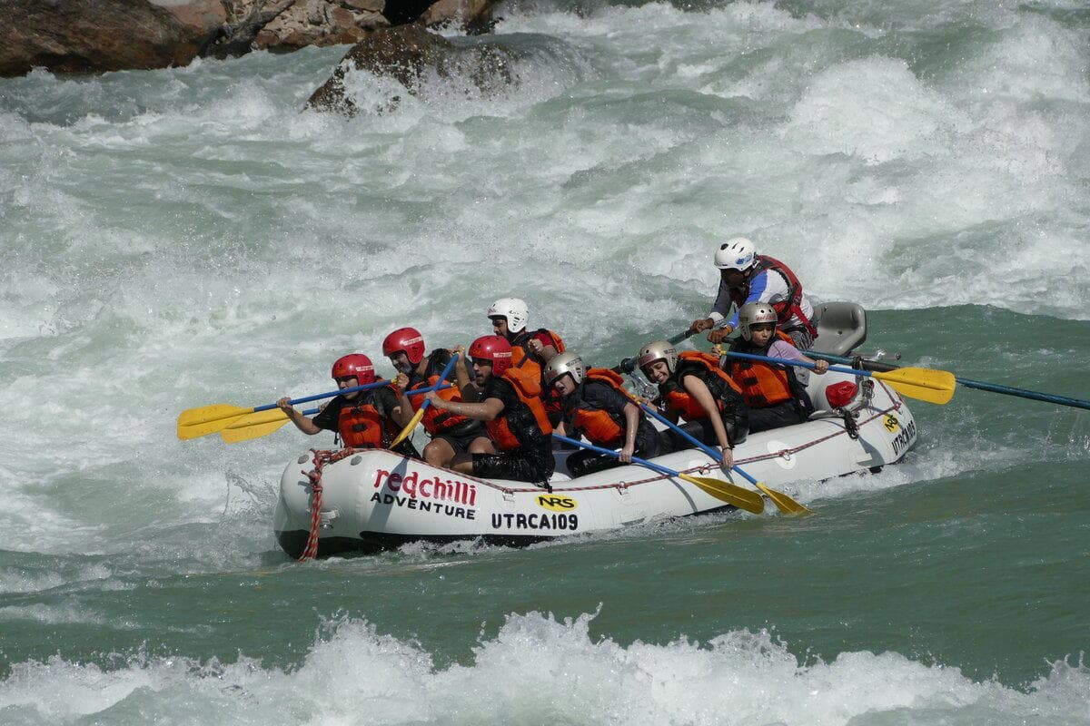A rafting team paddling through white water on the Ganga