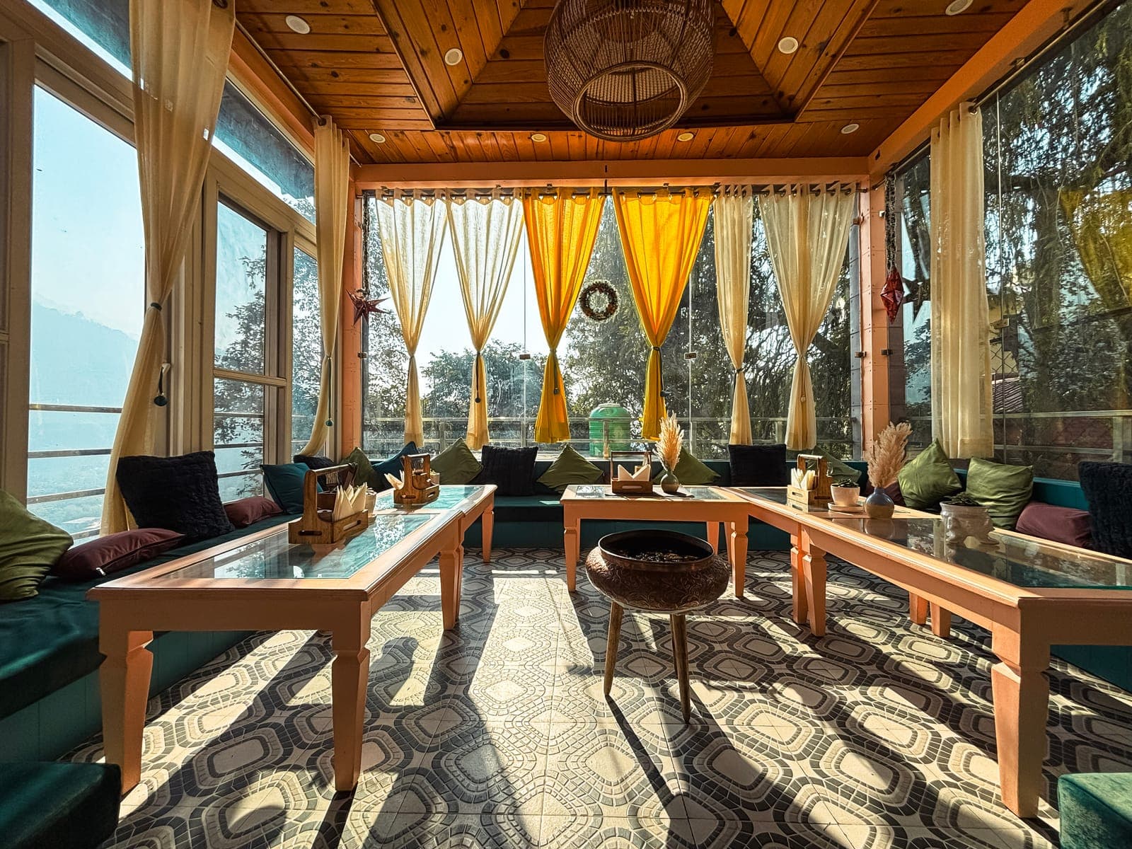 The in-house cafe at Aroma Cafe Hotel, Rishikesh, with mountain views through the windows