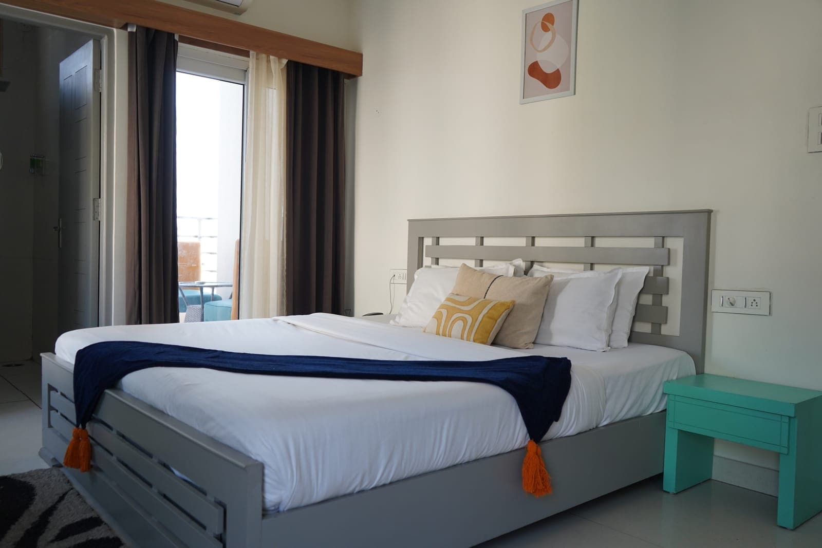 The bed in the Deluxe Room with Balcony at Aroma Cafe Hotel, Rishikesh