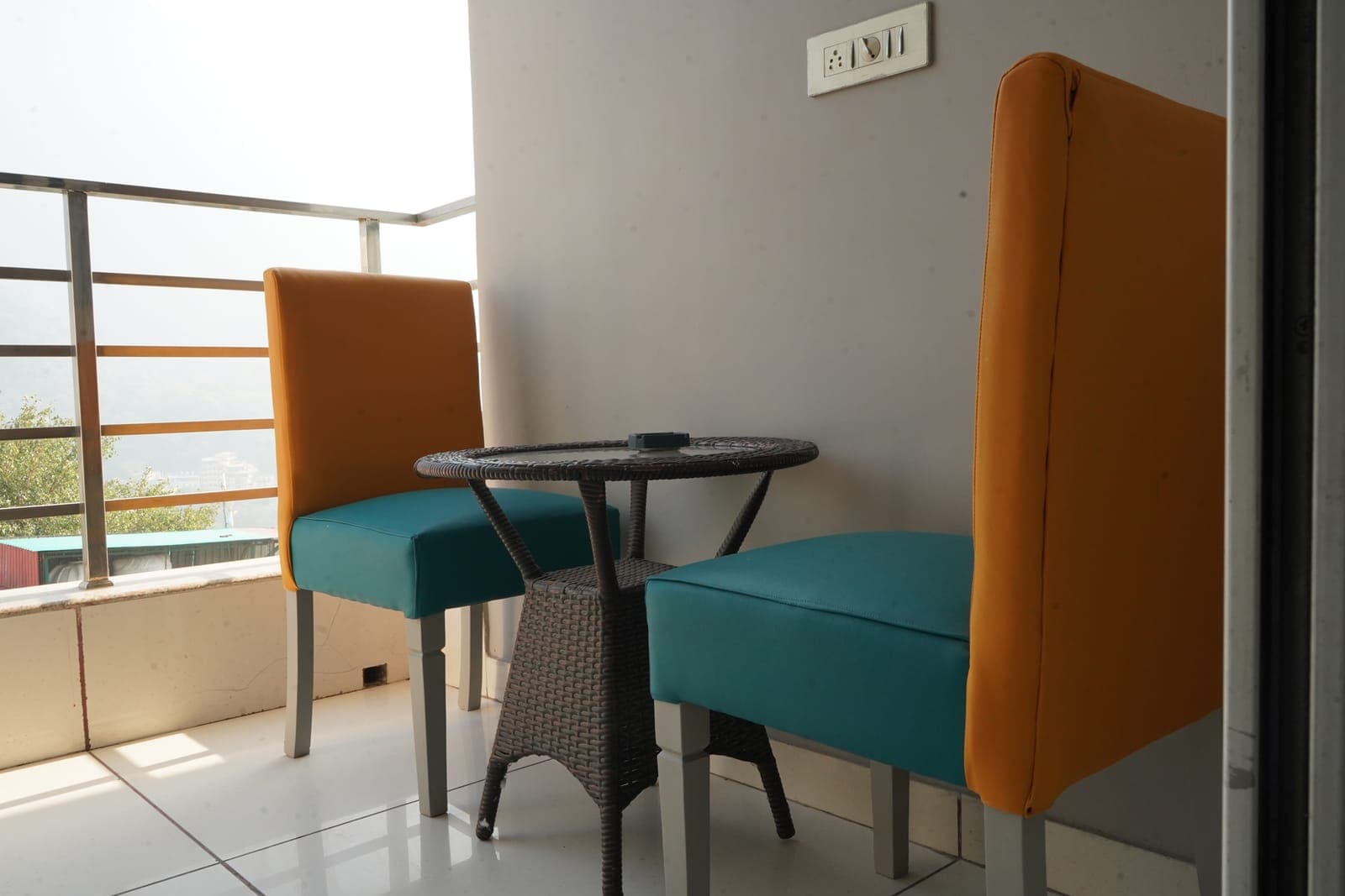 The private balcony seating in the Deluxe Room with Balcony at Aroma Cafe Hotel, Rishikesh