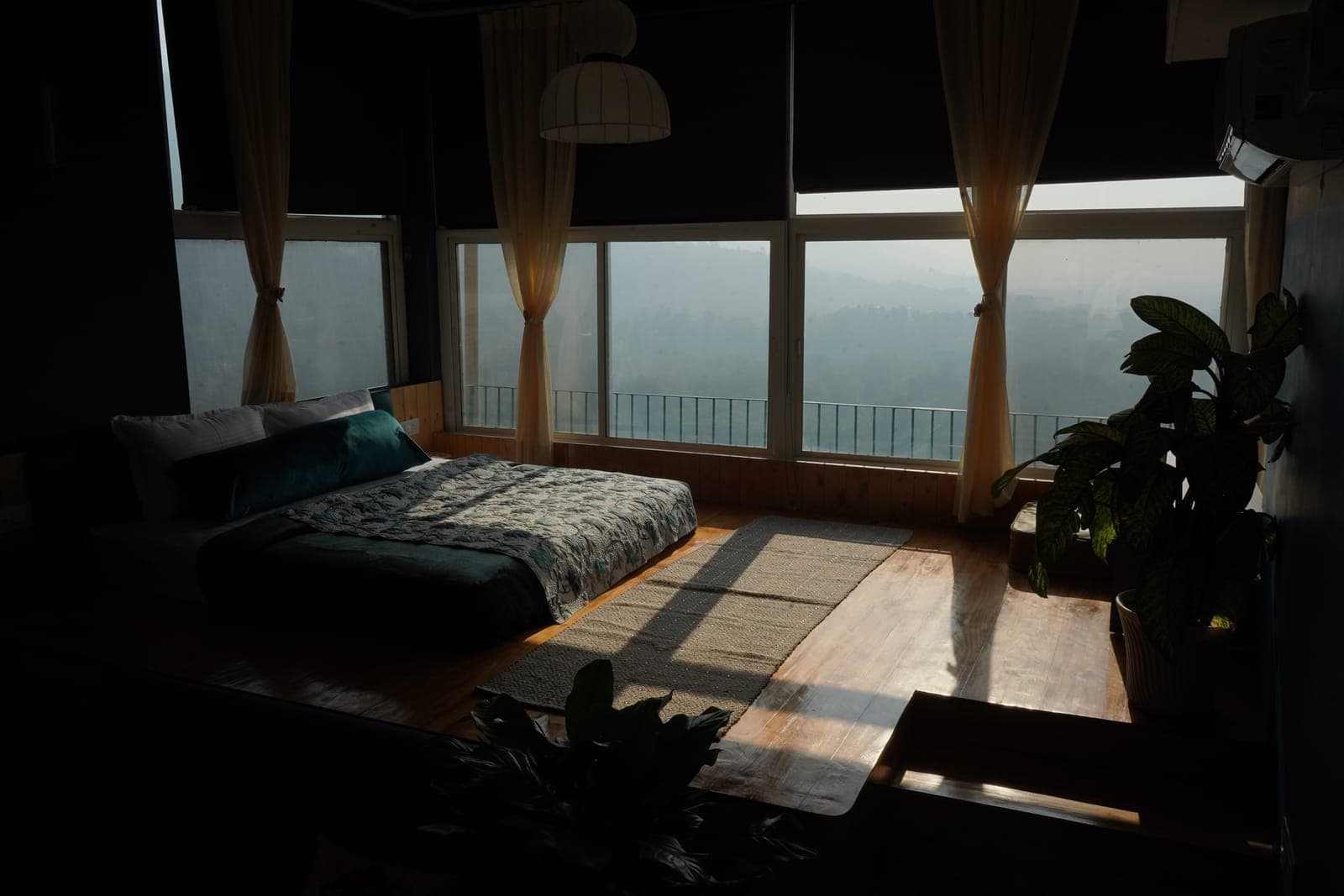 The Loft room at dusk, with the valley view through the windows, at Aroma Cafe Hotel, Rishikesh