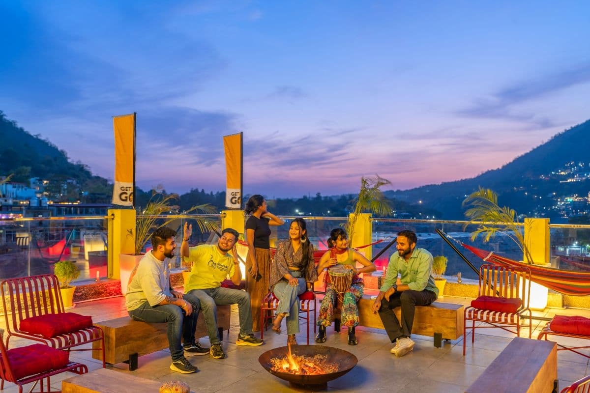 Rooftop terrace bonfire at dusk at The Hosteller Rishikesh, Ganges
