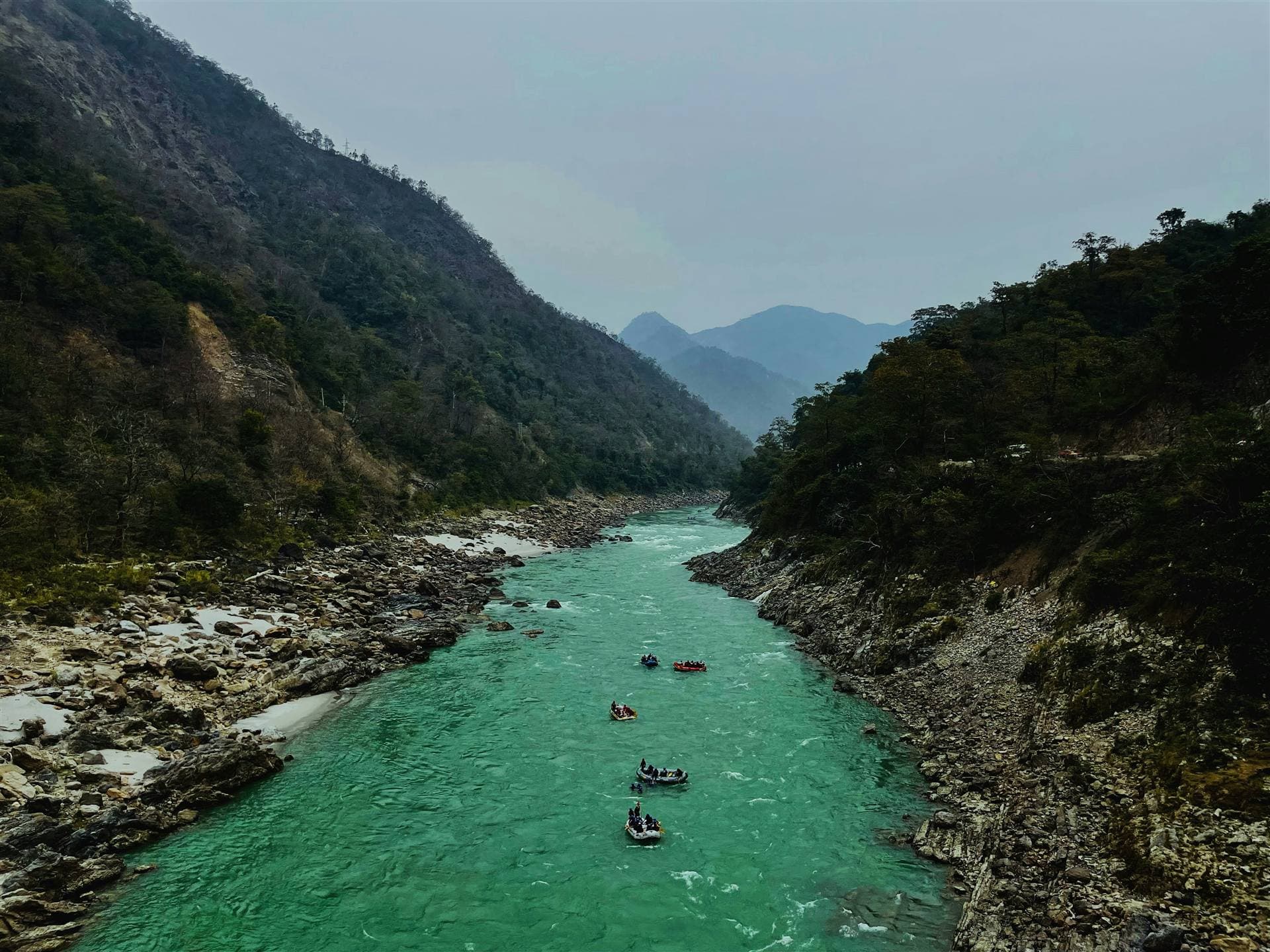 Rafts drifting through an emerald Ganga gorge near Rishikesh