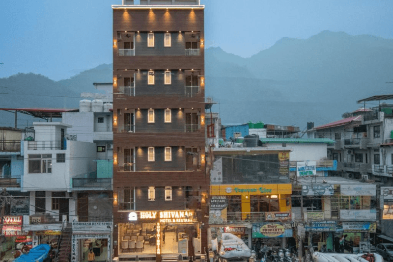 Holy Shivana's building at dusk against the Tapovan hills, Rishikesh